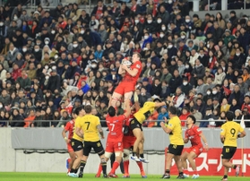 満員のスタンドを背に熱戦を繰り広げる神戸製鋼とサントリーの選手ら＝１月２６日、神戸市兵庫区、ノエビアスタジアム神戸