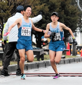 男子・須磨学園の３区喜多村慧（左）からたすきを受ける４区八沢輝人
