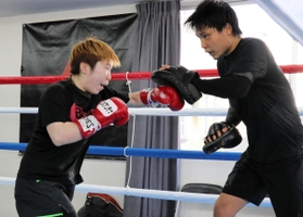 元世界王者の久保隼（右）を相手にミット打ちに励む山中菫＝神戸市東灘区、真正ジム