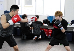 プロテストに向け、兄で元世界王者の山中竜也さん（左）とマスボクシングをする山中菫＝神戸市東灘区、真正ジム