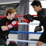 元世界王者の久保隼（右）を相手にミット打ちに励む山中菫＝神戸市東灘区、真正ジム