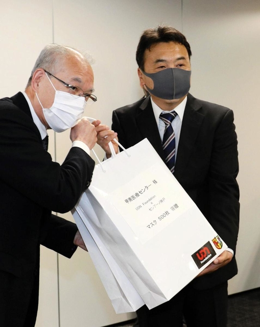 香川真司が無償提供したマスクを届けた恩師の大木宏之さん（右）と甲南医療センタ-の具英成院長＝神戸市東灘区