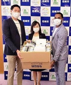 稲村和美市長（中央）にマスクを手渡すアサヒ飲料の川口陽生（左）とブライソン・ブリス＝尼崎市役所（チーム提供）