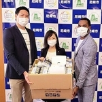 稲村和美市長（中央）にマスクを手渡すアサヒ飲料の川口陽生（左）とブライソン・ブリス＝尼崎市役所（チーム提供）