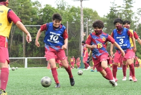 マスク代わりのネックチューブを着用し、練習する神戸弘陵高の男子サッカー部員。サッカーも代替大会開催が決まった＝１日、神戸市北区山田町（撮影・後藤亮平）