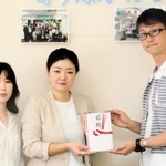 寄付金の目録を長田こどもホームの王子光仁施設長（右）に手渡すイ・ボミの李彩瑛マネジャー（中央）ら＝神戸市長田区