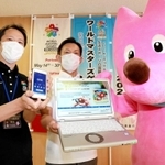 大会をＰＲする「ワールドマスターズゲームズ２０２１関西」兵庫県実行委の職員と大会マスコットキャラのスフラ（右）＝兵庫県神戸総合庁舎