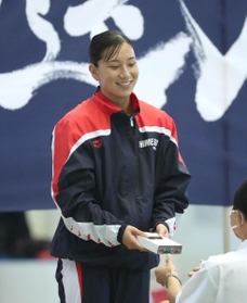 女子５０メートル自由形を大会新記録で制し、表彰式で笑顔を見せる姫路商高の舩本愛子＝神戸市立ポートアイランドスポーツセンター（撮影・辰巳直之）