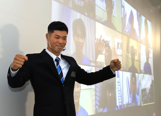 オンライン画面を通じ、チームメートから祝福される近大の佐藤輝明内野手＝２６日午後、大阪府東大阪市