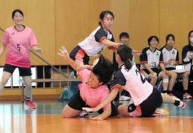 試合終了直前、果敢な攻撃で相手の反則を誘った武庫川女大の４年木村（中央）。直後の７メートルスローで４年生の全員得点を完成させた＝西宮市武庫川町