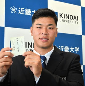 近大の佐藤輝明内野手が阪神・矢野燿大監督から受け取った交渉権獲得カードには「一途一心」のメッセージ＝２７日午後、大阪府東大阪市の近畿大学