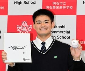 ロッテの井口資仁監督のサインボールと色紙を手に笑顔を見せる明石商の中森俊介投手＝明石市の同校（撮影・中西幸大）