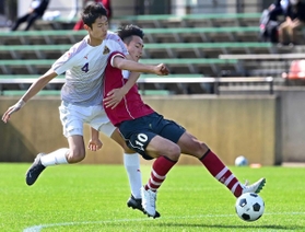 神戸国際大付－三田学園　前半、相手選手ともつれながら先制点を決める三田学園の長野（右）＝撮影・秋山亮太