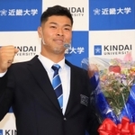 ４球団から１位指名されて阪神との交渉が決まり、花束を手にガッツポーズをする佐藤輝明選手＝２６日午後、大阪府東大阪市小若江３、近畿大学東大阪キャンパス（撮影・斎藤雅志）