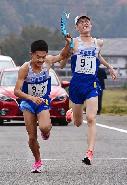 男子・須磨学園の１区広内颯（右）からたすきを受け取る２区林田蒼生（撮影・秋山亮太）