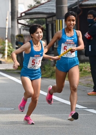 女子・須磨学園の２区道清愛紗（右）からたすきを受け取る３区福永愛佳（撮影・秋山亮太）