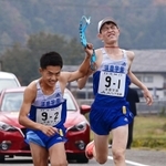 男子・須磨学園の１区広内颯（右）からたすきを受け取る２区林田蒼生（撮影・秋山亮太）