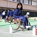 車いすに乗り、陸上スラロームを体験する女子生徒＝神戸市兵庫区会下山町３、神港橘高校