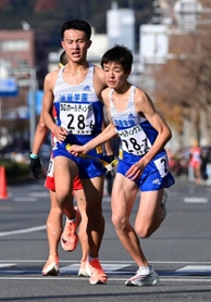 男子・須磨学園の６区国安広人（左）からたすきを受け走り出すアンカー八沢輝人＝２０日午後、京都市中京区（撮影・秋山亮太）