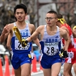 男子・す真学園の２区林田蒼生（左）からたすきを受け走り出す３区永吉恭理＝２０日午後、京都市内（撮影・秋山亮太）