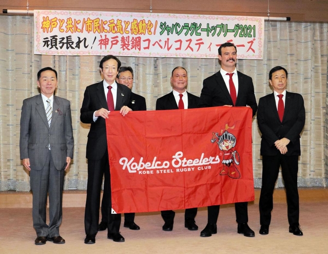 神戸市の久元喜造市長（左から２人目）と記念撮影に臨む神戸製鋼のトム・フランクリン共同主将（右から２人目）＝神戸市役所