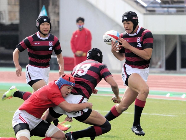 Ｂブロック決勝・神戸科技-報徳　前半、パスを受けて敵陣に切り込む報徳の選手（右）＝神戸市須磨区、ユニバー記念競技場
