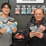 開発した靴下を持つミムラボの三村仁司さん（右）と長男で専務の修司さん＝加古川市東神吉町神吉