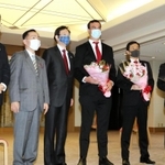 神戸市の久元喜造市長（左から３人目）らと記念撮影に臨む神戸製鋼のトム・フランクリン共同主将（同４人目）＝神戸市役所