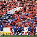 開幕戦でボールを奪い合う神戸製鋼とＮＥＣの選手たち。観客は間隔を空けて座り、戦況を見守った＝２０日午後、大阪府東大阪市、花園ラグビー場（撮影・後藤亮平）