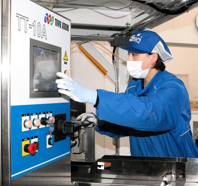 観賞魚用飼料の工場で働くＡＣ播磨イーグレッツの鎌田有芽選手。機械操作もお手のもの＝兵庫県福崎町西治、キョーリンフード工業福崎工場