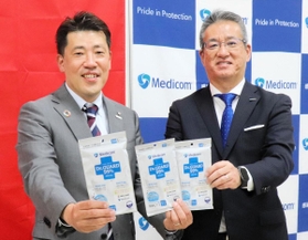 メディカルパートナー契約を結びＩＮＡＣ神戸の安本卓史社長（左）にマスクを手渡すメディコムジャパンの藤原慎一社長＝神戸市東灘区向洋町中７