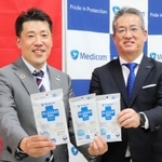 メディカルパートナー契約を結びＩＮＡＣ神戸の安本卓史社長（左）にマスクを手渡すメディコムジャパンの藤原慎一社長＝神戸市東灘区向洋町中７
