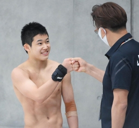 男子高飛び込み準決勝を終えて馬淵崇英コーチ（右）と拳を合わせる玉井陸斗＝３日午後、東京アクアティクスセンター（撮影・堀内翔）