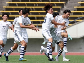 サッカー男子決勝・報徳-関学　試合終了間際、決勝点を決めてチームメートに祝福される関学のＤＦ紀伊野敬大（右）＝神戸市須磨区緑台、ユニバー記念競技場（撮影・長嶺麻子）