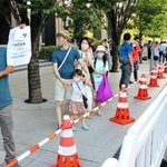 東京五輪の開会式前、国立競技場近くでインドを応援する紙を掲げる人。記者とも目が合い、互いにうなずき合った＝２３日午後５時２２分、東京都新宿区