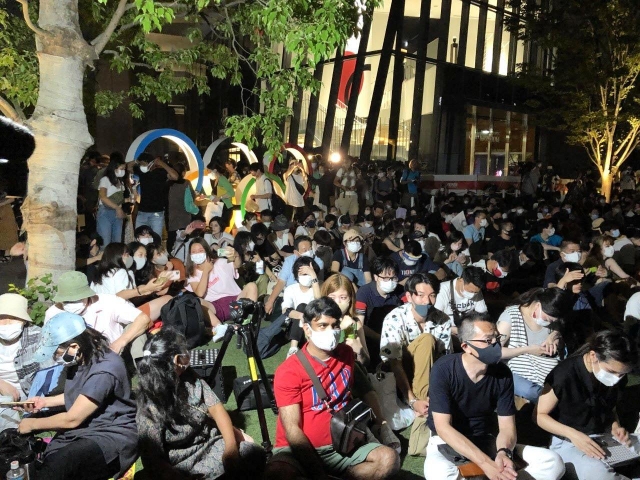 五輪マークのモニュメント前は開会式前から見物客で埋め尽くされていた＝東京都新宿区