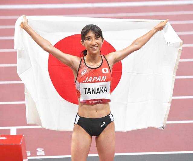 女子１５００メートル決勝　８位入賞し、日の丸を背に笑顔を見せる田中希実＝国立競技場（撮影・高部洋祐）