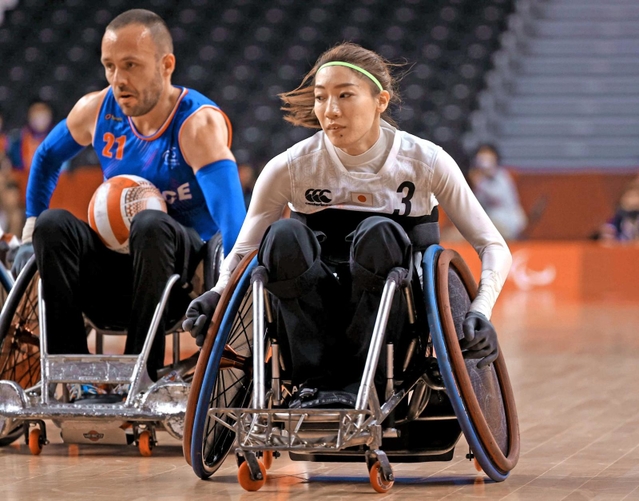 車いすラグビー１次リーグのフランス戦で初出場し、相手の進路に先回りする倉橋香衣（右）＝２５日、代々木競技場（撮影・吉田敦史）