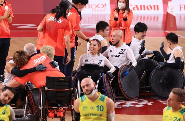 車いすラグビーで２大会連続の銅メダルに輝き、喜び合う倉橋香衣（中央）ら日本チーム＝２９日午後、代々木競技場（撮影・吉田敦史）