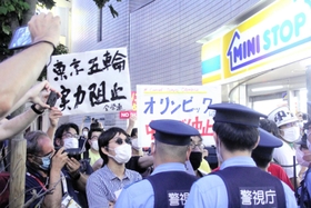 国立競技場近くの歩道で警察官ともみ合うデモ隊＝東京都渋谷区