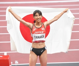 女子１５００メートル決勝　８位入賞し、日の丸を背に笑顔を見せる田中希実＝国立競技場（撮影・高部洋祐）