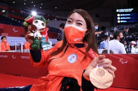 車いすラグビーで２大会連続の銅メダルに輝き、メダルとブーケを掲げる倉橋香衣＝代々木競技場（撮影・吉田敦史）