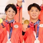 柔道のメダリスト会見で金メダルを手に笑顔を見せる阿部詩（左）と兄の阿部一二三＝東京都中央区