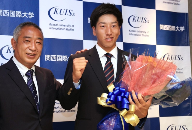 巨人から１位指名を受け、喜び合う関西国際大の翁田大勢（右）と鈴木英之監督＝１１日午後、三木市志染町青山１（撮影・吉田敦史）