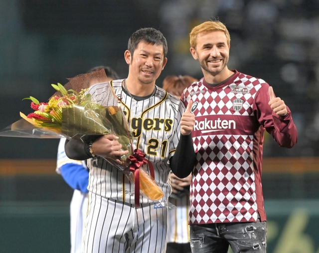 試合前、記念写真に納まる阪神・岩田稔（左）とヴィッセル神戸のセルジ・サンペール＝２６日、甲子園