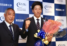 巨人から１位指名を受け、喜び合う関西国際大の翁田大勢（右）と鈴木英之監督＝１１日午後、三木市志染町青山１（撮影・吉田敦史）