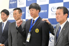 巨人の水野雄仁スカウト部長（左から２人目）、大塚淳弘副代表（右）らと写真に収まる関西国際大の翁田大勢投手＝三木市の同大学