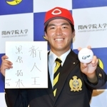 広島から１位指名され、「新人王」の色紙を手に笑顔を見せる関学大の黒原拓未＝西宮市の同大学（撮影・佐々木彰尚）