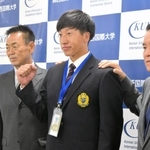 巨人の水野雄仁スカウト部長（左から２人目）、大塚淳弘副代表（右）らと写真に収まる関西国際大の翁田大勢投手＝三木市の同大学