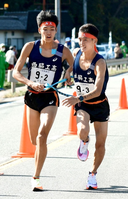 男子・西脇工の２区山中達貴（左）からたすきを受ける３区塩田大空（撮影・坂井萌香）